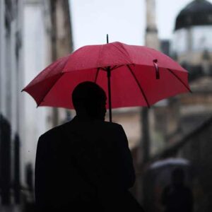 Un homme tient un parapluie pour se protéger